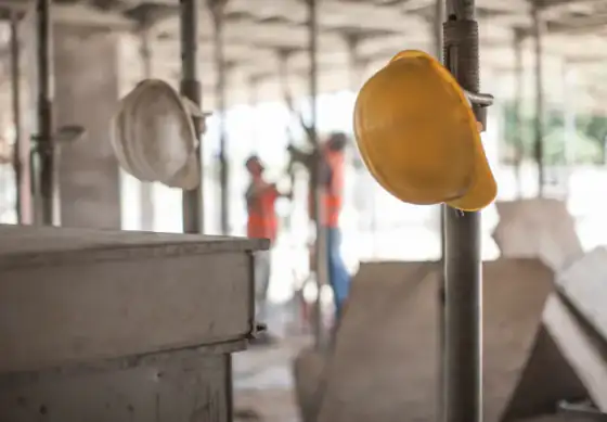 Escoras em uma obra com capacetes de obra EPI